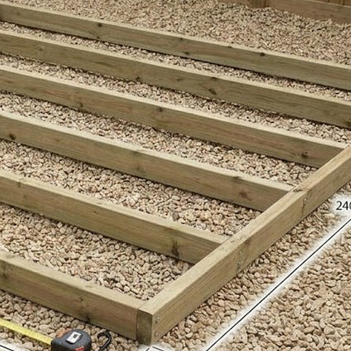 Close-up of pressure-treated timber shed base frame and joist spacing